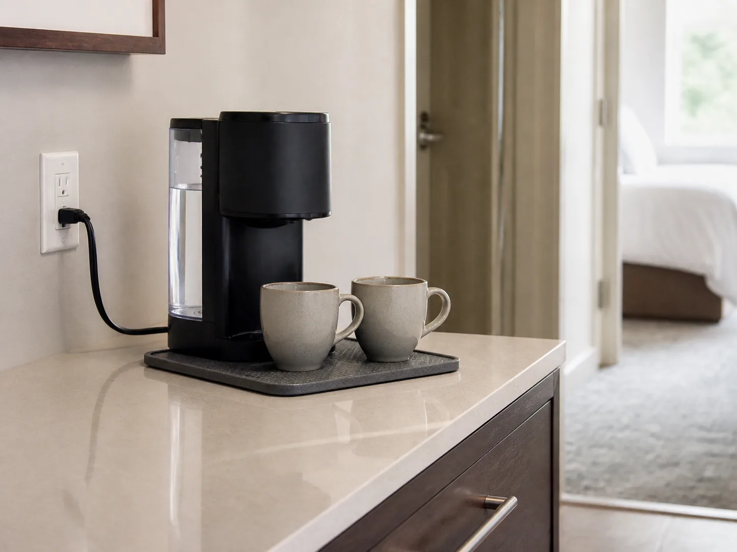 Compact coffee maker on a clear counter with a safe wall-outlet setup and space around the appliance