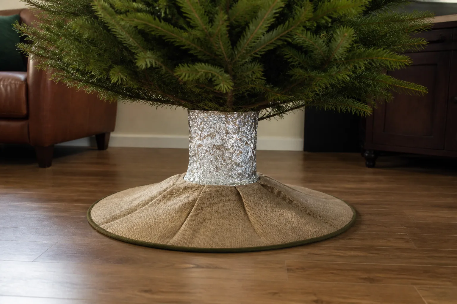 Christmas tree trunk wrapped in aluminum foil with a fitted skirt covering the water reservoir