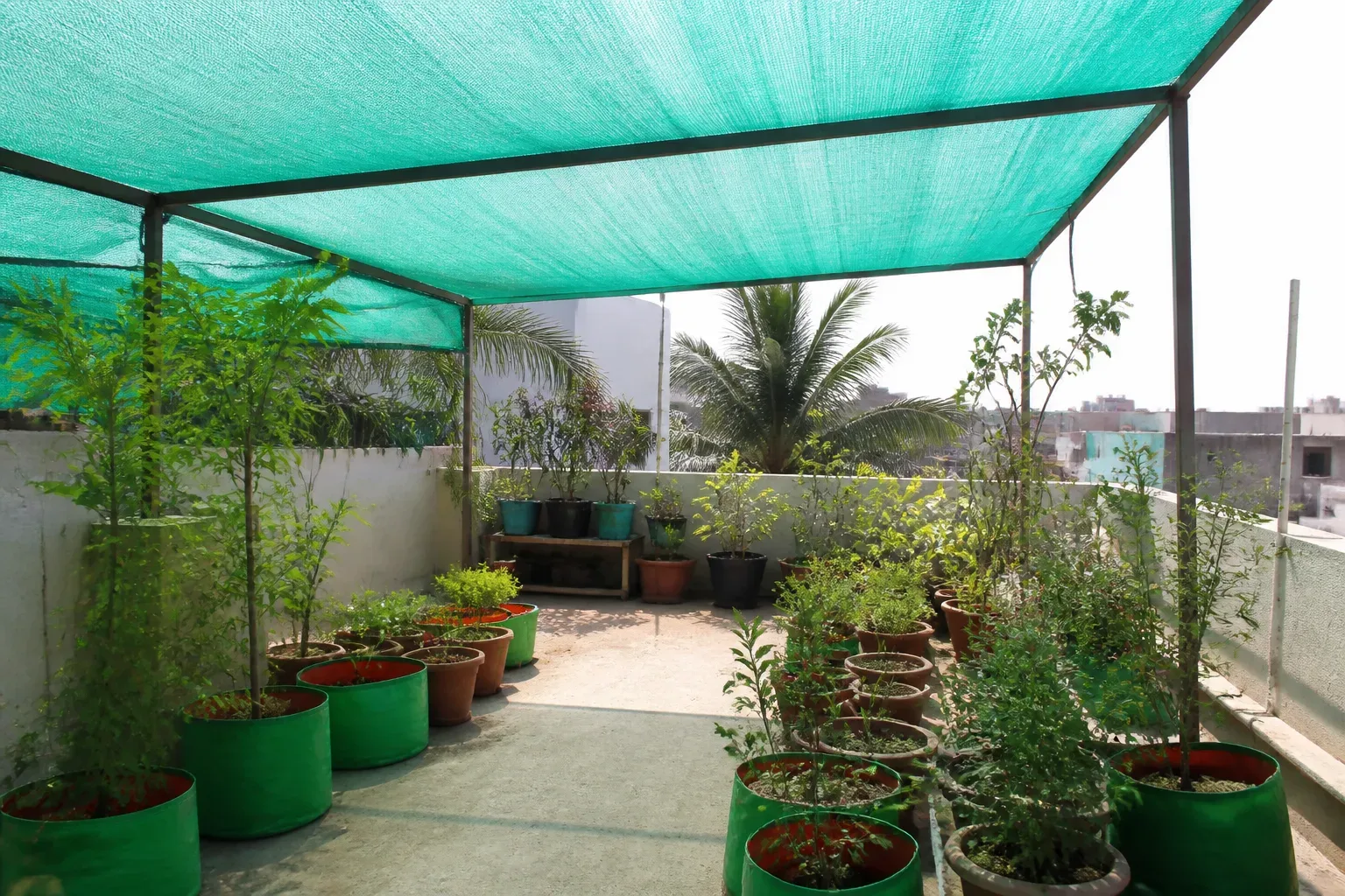 Shade net bay protecting terrace plants from harsh midday sun