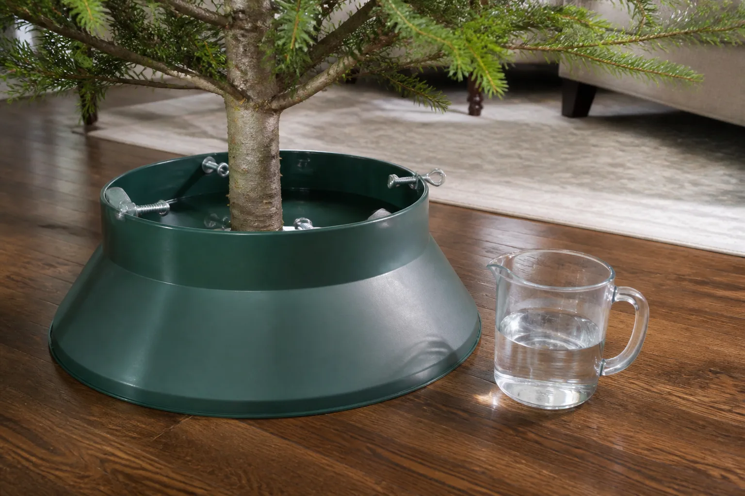 Large-capacity Christmas tree stand filled with clear water beside a measuring cup
