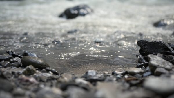 a close up of rocks and water on a beach
